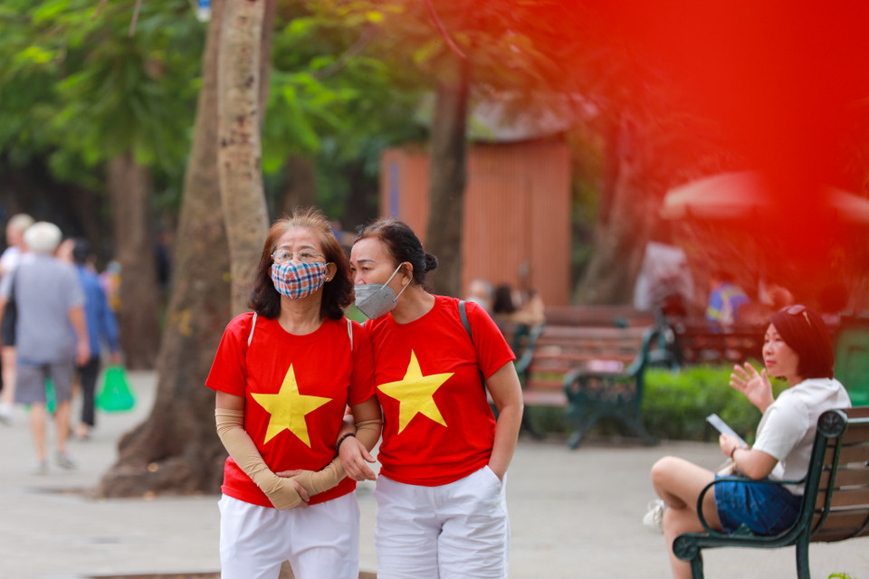 Khắp nơi cờ đỏ sao vàng phấp phới tung bay, người dân mặc áo cờ Tổ quốc. (Ảnh: Minh Sơn/Vietnam+)