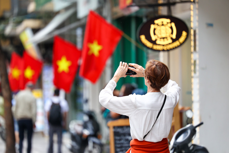 Nhiều du khách quốc tế thích thú chụp lại khoảnh khắc hiếm hoi trong năm Hà Nội khoác lên mình màu áo mới. (Ảnh: Minh Sơn/Vietnam+)
