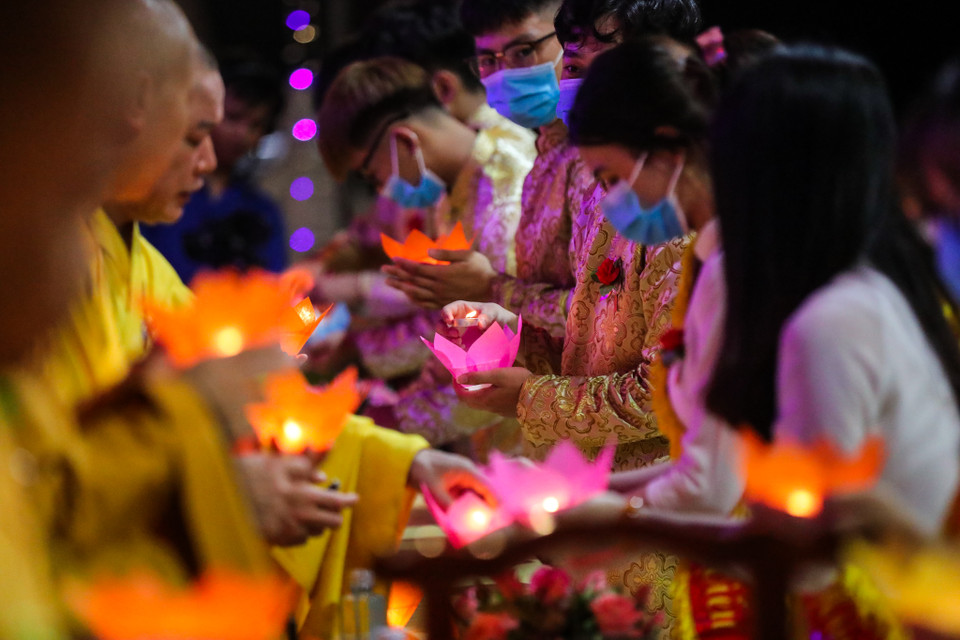 Hàng trăm ngọn nến được các Phật tử truyền tay nhau tạo nên không gian lung linh sắc màu. (Ảnh: Minh Sơn/Vietnam+)