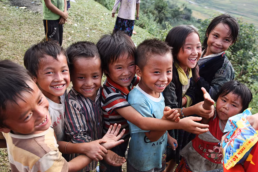 Cười tươi khi được các anh chị cho kẹo. (Ảnh Minh Sơn/Vietnam+) 