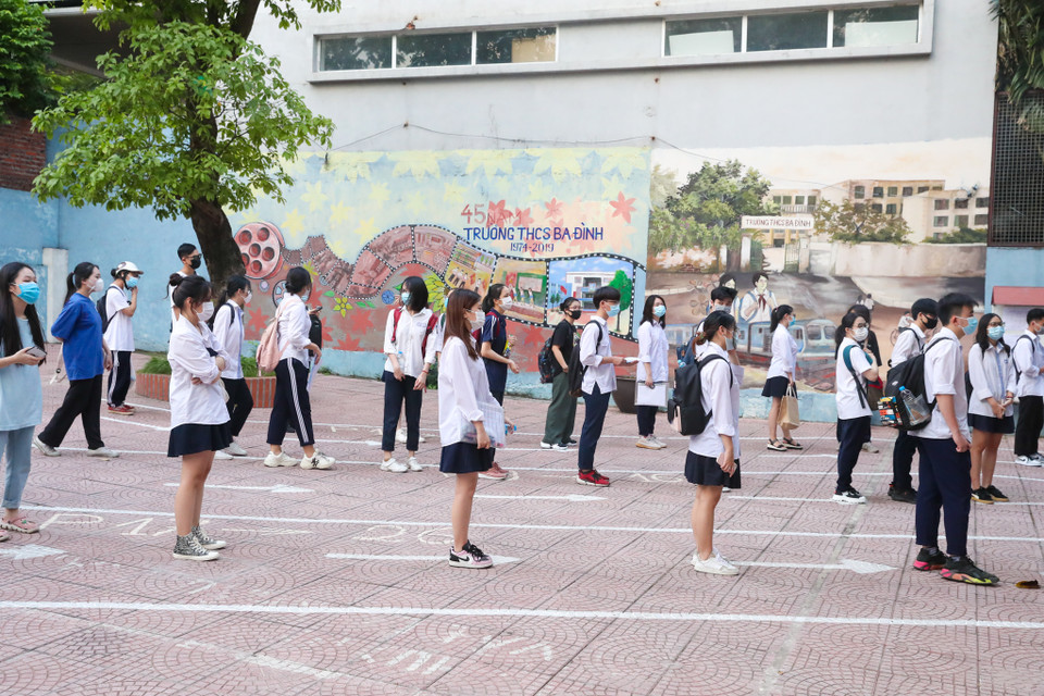 Các thí sinh đến điểm thi phải đứng giãn cách, lần lượt đi vào theo chỉ dẫn của cán bộ coi thi. (Ảnh: Minh Sơn/Vietnam+)