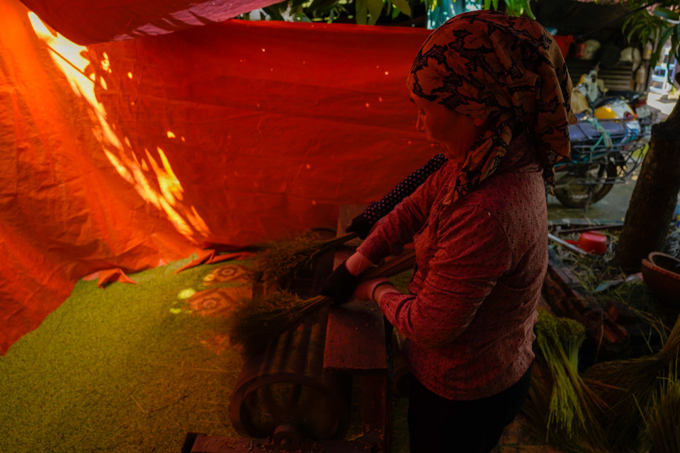 Với người làm cốm, khâu quan trọng nhất là khi rang phải đều lửa. (Ảnh: PV/Vietnam+)