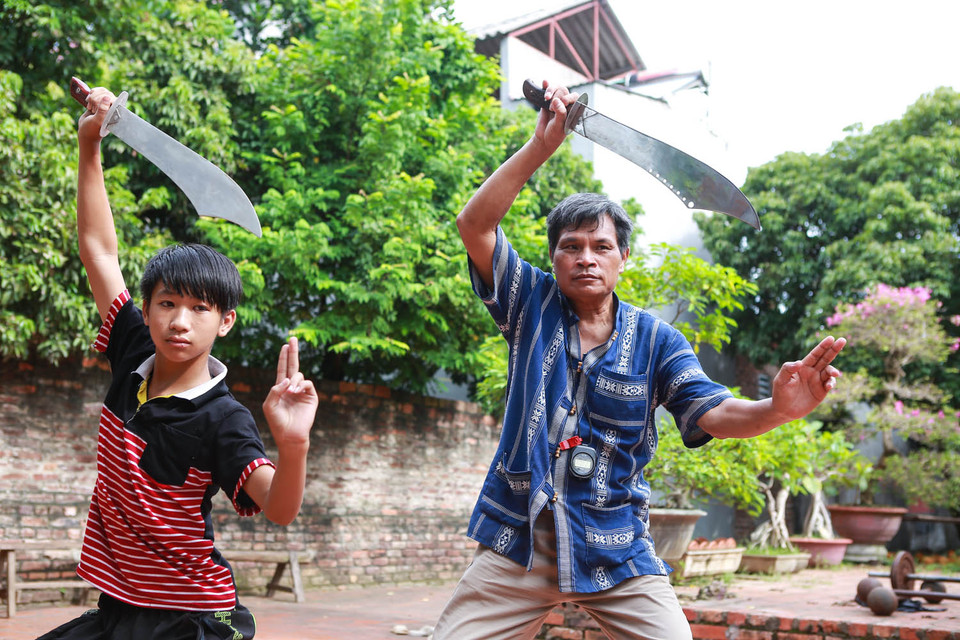 Nhìn ông múa võ, không mấy ai có thể nhận ra ông là một thương binh với một mảnh bom găm trong cột sống khiến cổ không thể cử động như bình thường. Thế nhưng với người chiến sĩ già, điều đó không làm ông nản lòng và tiếp tục truyền dạy võ thuật cho các thế hệ sau. (Ảnh: Minh Sơn/Vietnam+)