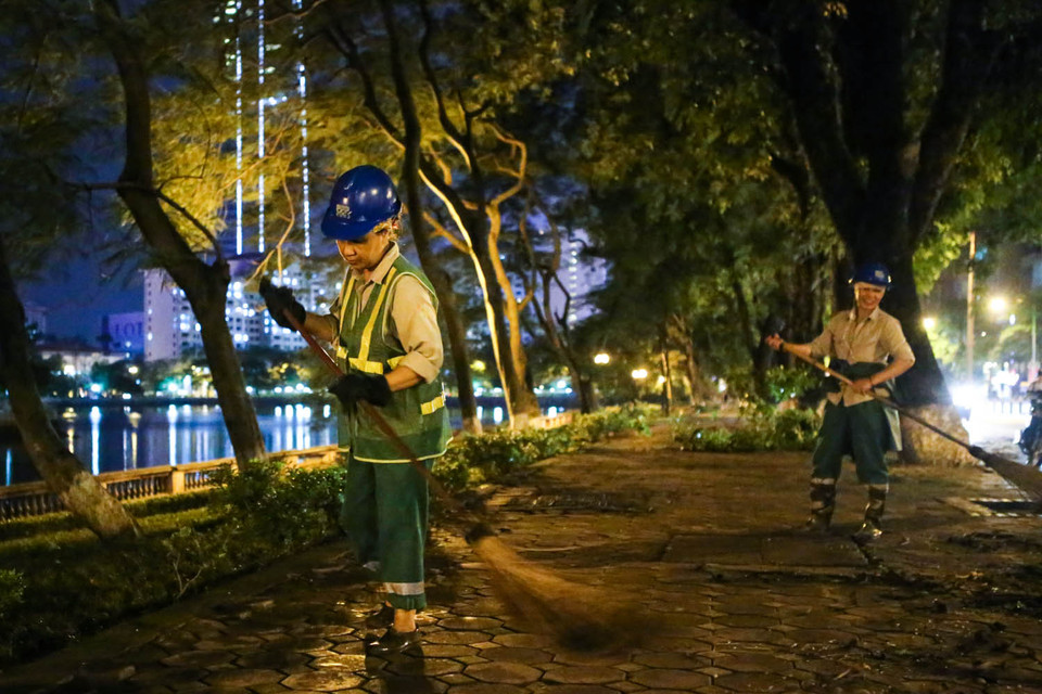 Những công nhân vệ sinh môi trường đang dọn dẹp lại hiện trường mà ‘ông trời’ đã gây ra. (Ảnh: Minh Sơn/Vietnam+)