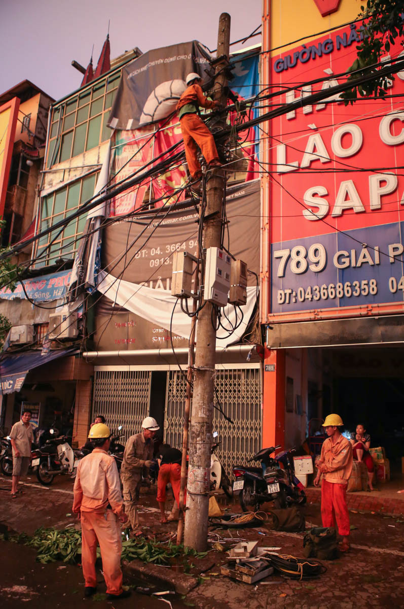 Nhân viên công ty Điện lực cố gắng nối lại hệ thống điện đã bị đánh sập hoàn toàn. (Ảnh: Minh Sơn/Vietnam+)/span&gt;