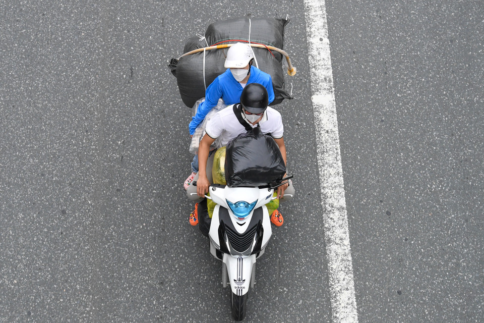 Nhiều gia đình lỉnh kỉnh mang đồ đạc về thành phố. (Ảnh: Minh Sơn/Vietnam+)