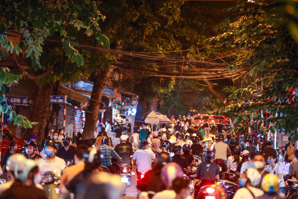 Thời điểm 18 giờ tối, rất đông người dân kéo đến phố Hàng Mã khiến lực lượng chức năng phải rất vất vả để nhắc nhở. (Ảnh: Minh Sơn/Vietnam+)