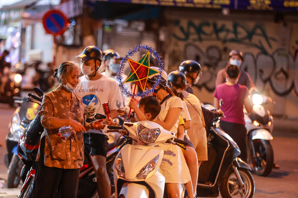 Nhiều người dân vội vã dừng lại mua đồ chơi rồi lại đi ngay. (Ảnh: Minh Sơn/Vietnam+)