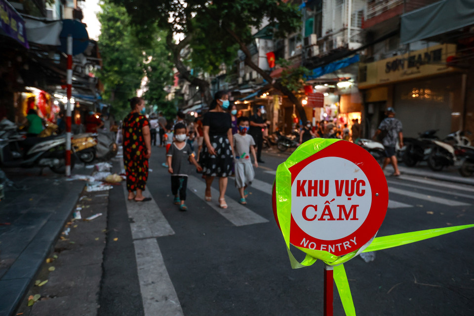 Hai chốt gồm 'chốt cứng' và 'chốt mềm'. Khu vực 'chốt cứng', lực lượng chức năng đã chăng dây không cho người dân qua lại, còn ở khu vực 'chốt mềm' người dân bên trong có thể ra ngoài, người dân bên ngoài sẽ không được vào. (Ảnh: Minh Sơn/Vietnam+)