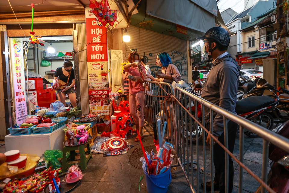 Nhiều người dân phải mua đồ chơi qua lớp hàng rào cứng. (Ảnh: Minh Sơn/Vietnam+)