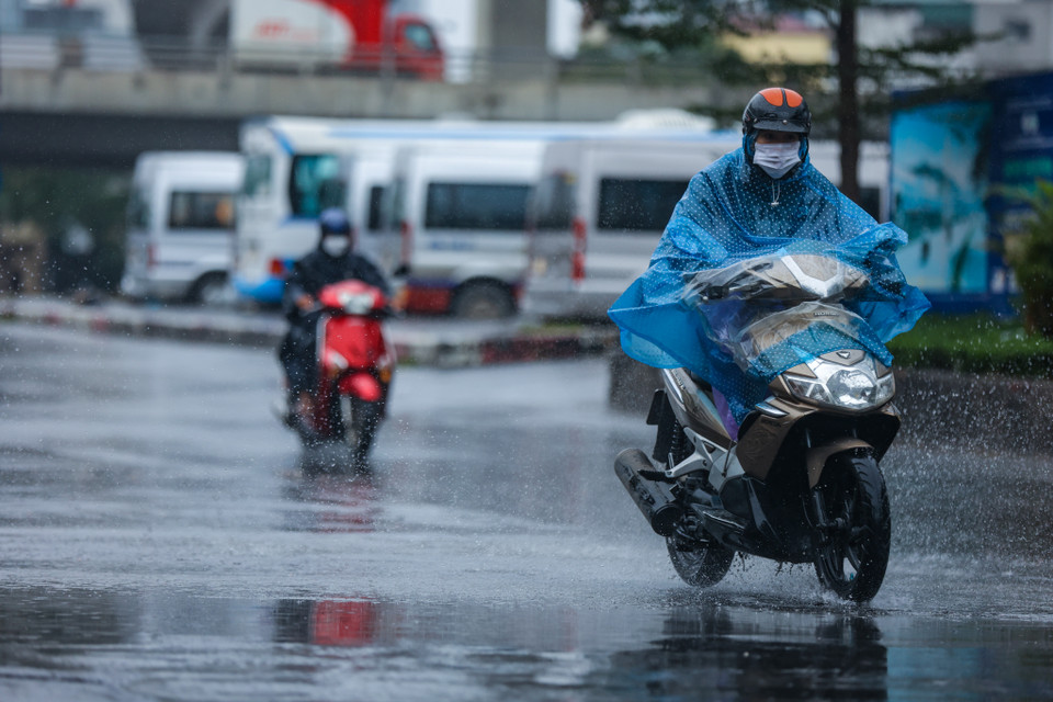 Trời rét đậm kèm với mưa rào khiến việc ra đường của người dân gặp nhiều khó khăn. (Ảnh: Minh Sơn/Vietnam+)