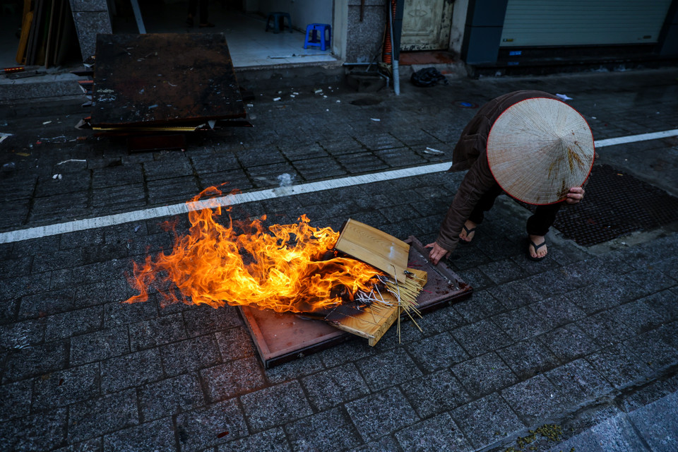 Cô Thủy (phố Nguyễn Thái Học, quận Ba Đình) cho biết mình phải đốt những vật dụng thừa để sưởi ấm vì lâu lắm mới gặp đợt rét như thế này. (Ảnh: Minh Sơn/Vietnam+)
