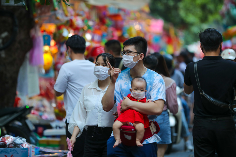 Gia đình anh Nguyễn Thanh Bình (Hải Dương) cho con nhỏ đi chơi Trung Thu dọc phố Hàng Mã. Mặc dù đây là lần đầu tiên tới đây nhưng anh Bình vẫn tuân thủ việc đeo khẩu trang phòng dịch cho cả nhà. (Ảnh: PV/Vietnam+)
