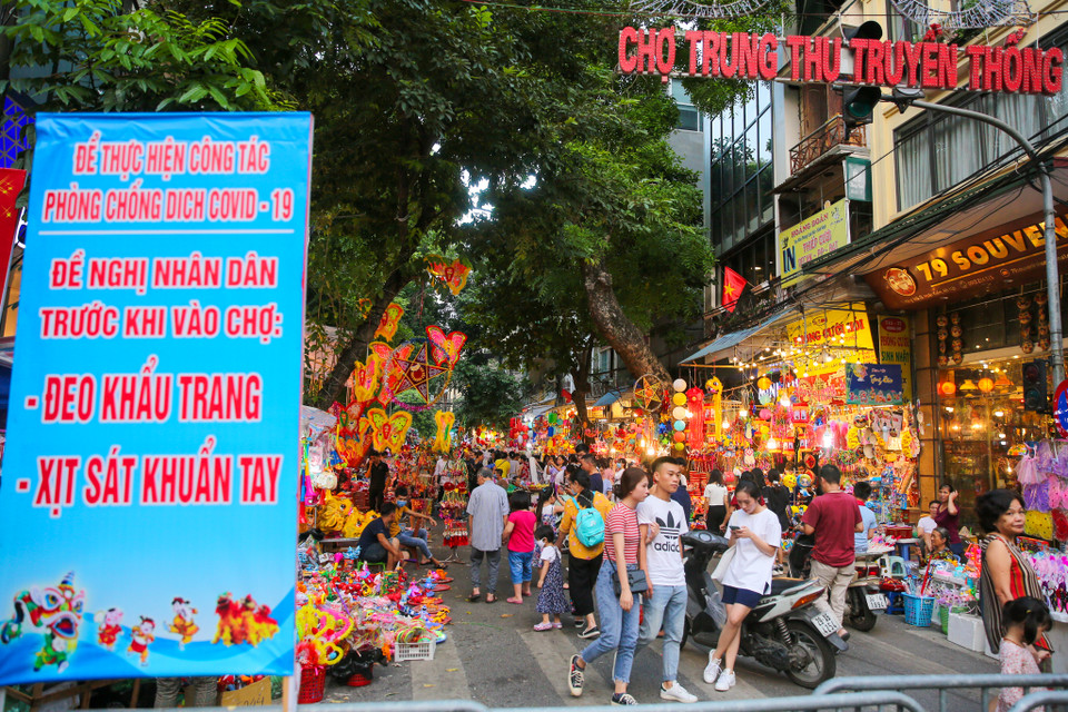 Mặc dù bên ngoài khu chợ Trung Thu truyền thống trên tuyến phố Hàng Mã, ban quản lý đã trưng biển yêu cầu người dân đeo khẩu trang và sát khuẩn tay nhưng nhiều người vẫn ngó lơ, không tuân thủ. (Ảnh: PV/Vietnam+)