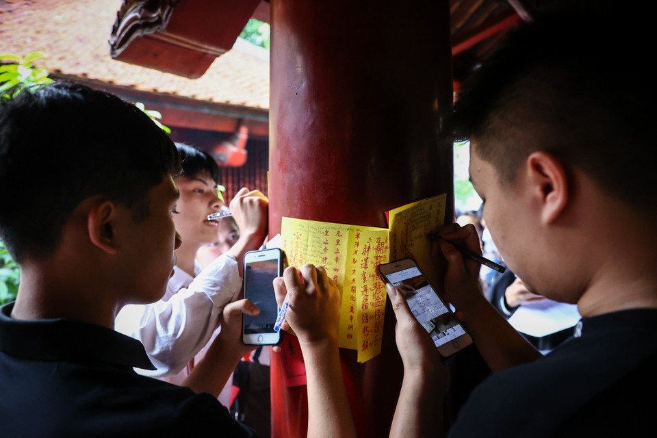 Nhiều sĩ tử viết tên, tuổi, địa chỉ, trường học lên sớ để thắp hương, cầu may trước kỳ thi quan trọng nhất cuộc đời. (Ảnh: Minh Sơn/Vietnam+)