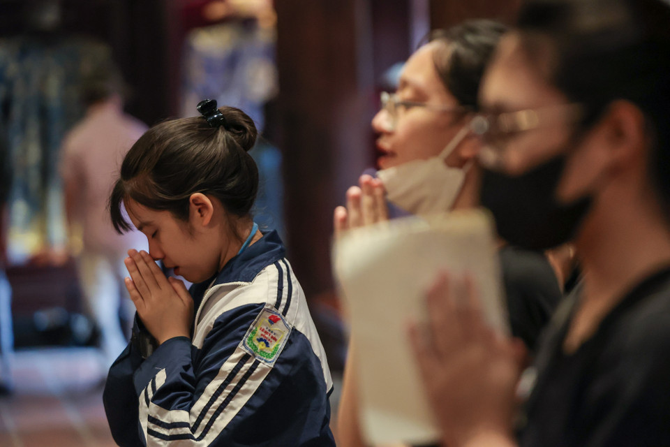 Các sĩ tử thành kính dâng hương, cầu mong thi cử đỗ đạt. (Ảnh: Minh Sơn/Vietnam+)