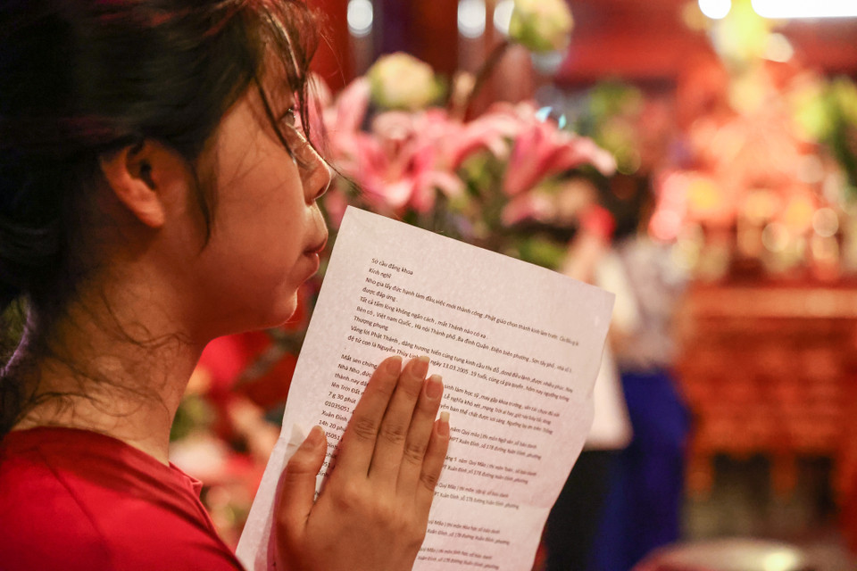 Nhiều thi sinh đã chuẩn bị cả Sớ cầu đăng khoa để đọc trước ban thờ nhà giáo Chu Văn An. (Ảnh: Minh Sơn/Vietnam+)