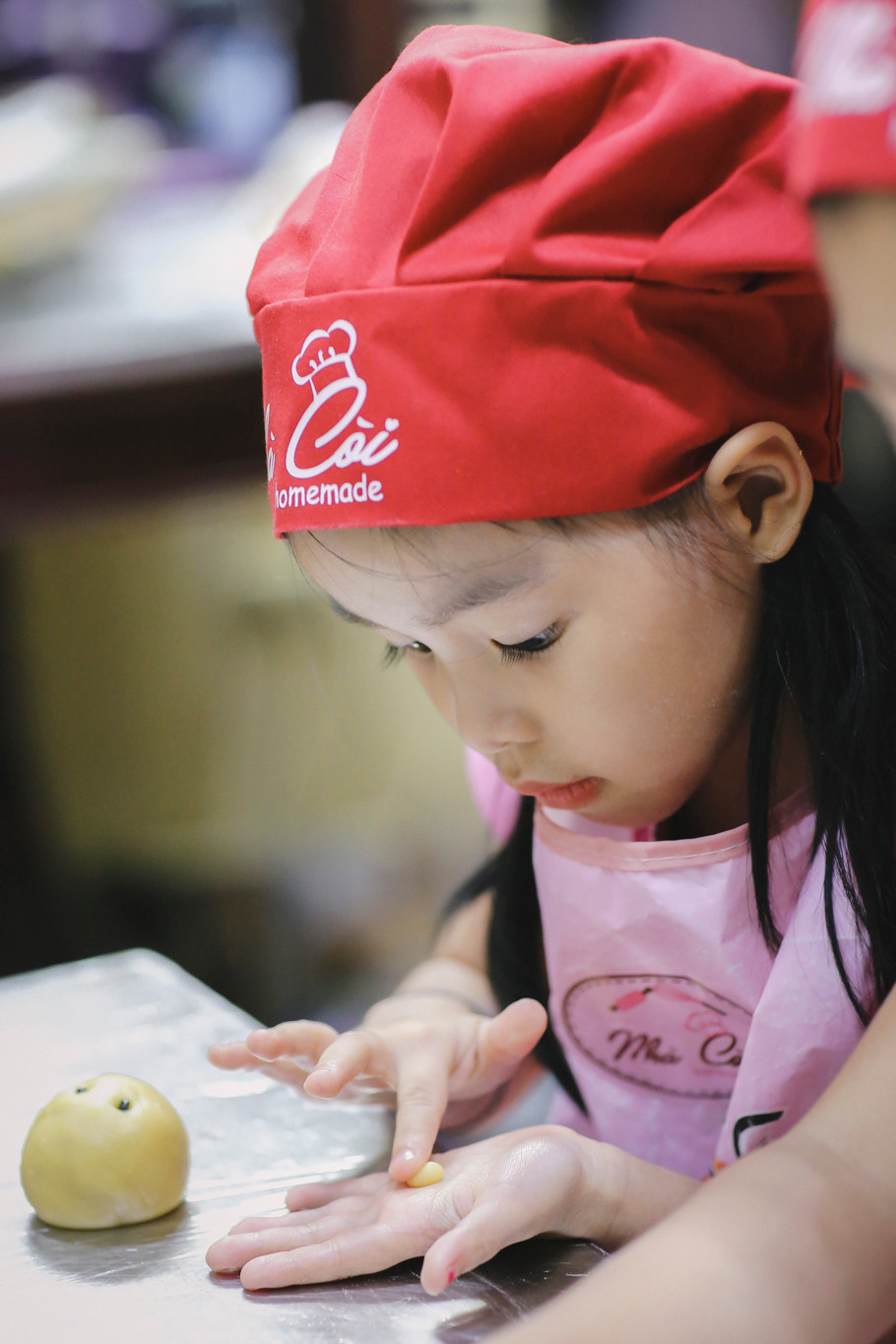 Nhìn thấy việc con em mình tỉ mẩn nhào bột, làm nhân rồi nặn thành hình những chiếc bánh xinh xắn, chắc chắn phụ huynh nào cũng rất vui vẻ. (Ảnh: Minh Sơn/Vietnam+)