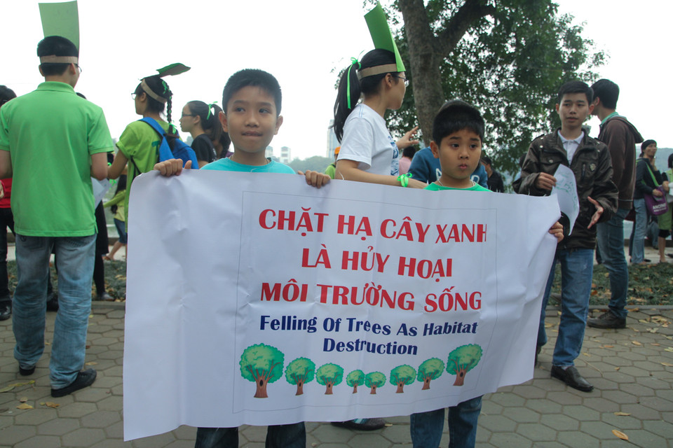 Nhiều em học sinh cũng cầm trên tay những khẩu hiệu nhằm bảo vệ cây xanh trong Thủ đô. (Ảnh: Minh Sơn/Vietnam+)