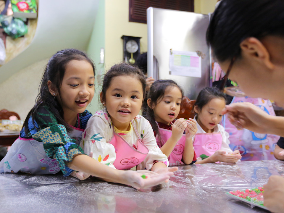 Bé Trịnh Khánh An (6 tuổi) con gái dễ thương của biên tập viên xinh đẹp Bạch Lan Phương, dẫn chương trình Thời trang và Cuộc sống trên VTV3 cũng tham gia lớp học làm bánh này. (Ảnh: Minh Sơn/Vietnam+)