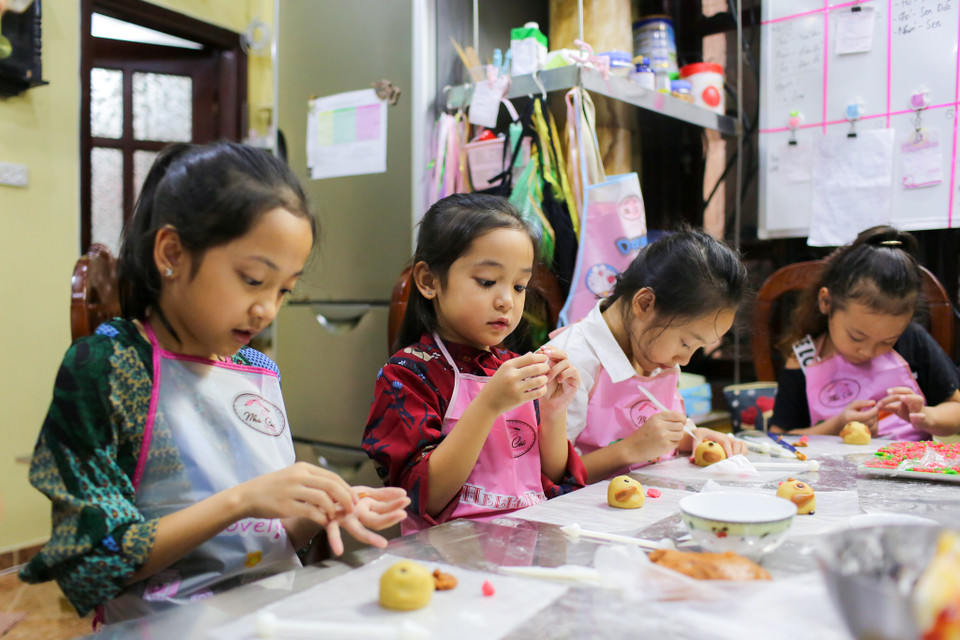 Những người mẫu nhí đều tỏ ra vô cùng hào hứng và thích thú khi được từ tay nhào bột, nặn bột, vê nhân làm bánh trung thu cho riêng mình. (Ảnh: Minh Sơn/Vietnam+)