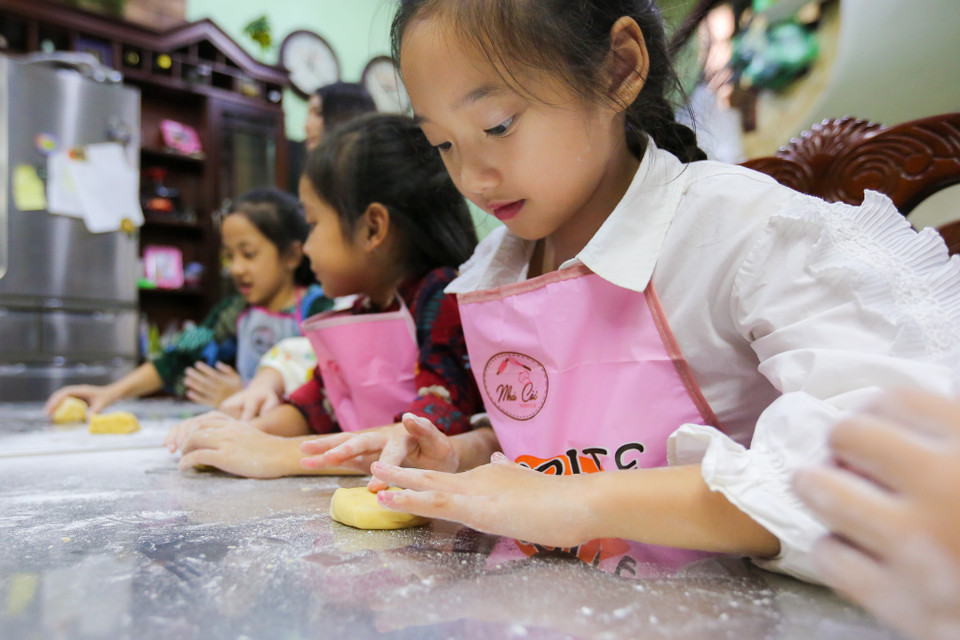 Trương Bảo Anh, cô bé sinh năm 2009 được ví như 'bản sao nhí' của nữ diễn viên nổi tiếng Châu Tấn đang say mê, chăm chú làm ra sản phẩm của chính mình. (Ảnh: Minh Sơn/Vietnam+)