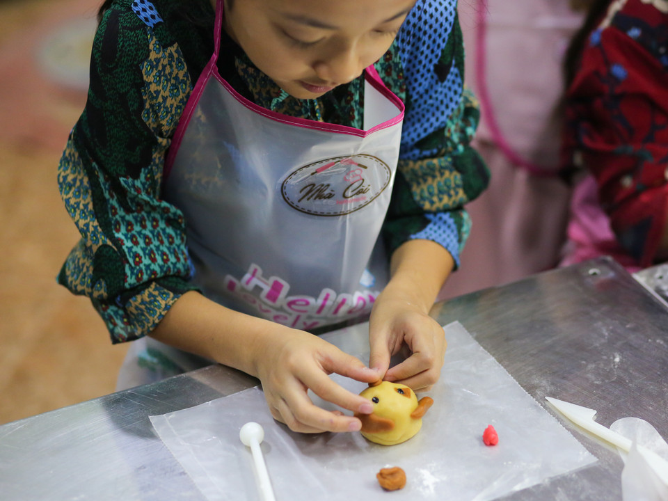 Chị Hoàng Phương Nhung, mẹ bé Diệp Anh (6 tuổi) và Phương Dung (8 tuổi) cho biết, chị muốn các con mình có một trung thu ý nghĩa hơn. 'Mọi năm mình vẫn mua bánh về cho các con nhưng năm nay mình lại muốn các bé đi học làm bánh trung thu để các bé có thể mang về tặng bố mẹ, ông bà và có một mùa Trung thu ý nghĩa'. (Ảnh: Minh Sơn/Vietnam+)