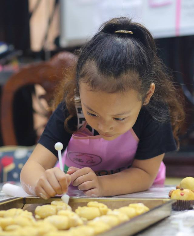 Bé Phan Ngọc Nam Phương (7 tuổi) có biệt danh là 'tiểu Chi Pu' thích thú khi tự mình hoàn thành chiếc bánh nướng hình con thỏ. (Ảnh: Minh Sơn/Vietnam+)