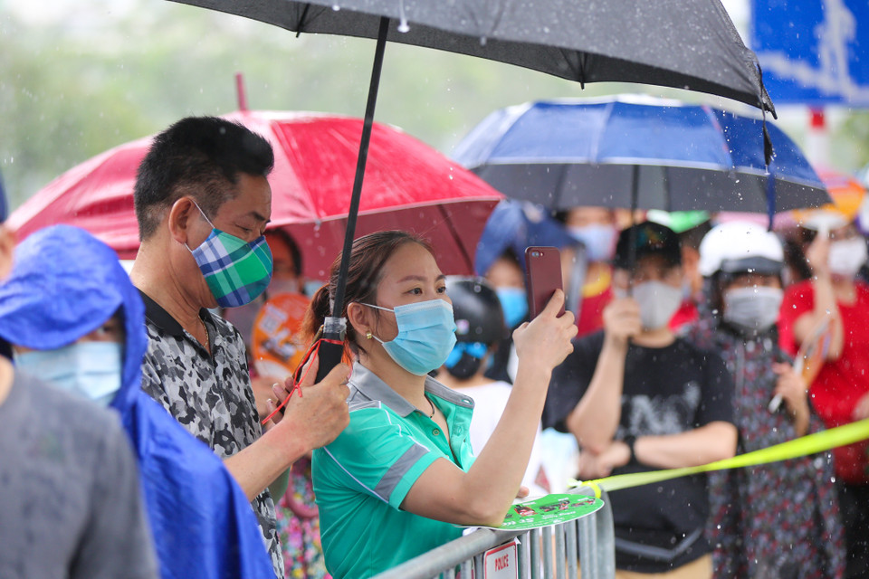 Các biện pháp bảo đảm phòng dịch COVID-19 vẫn được duy trì nghiêm ngặt khi phụ huynh phải đeo khẩu trang, đứng giãn cách để chờ con em mình. (Ảnh: Minh Sơn/Vietnam+)