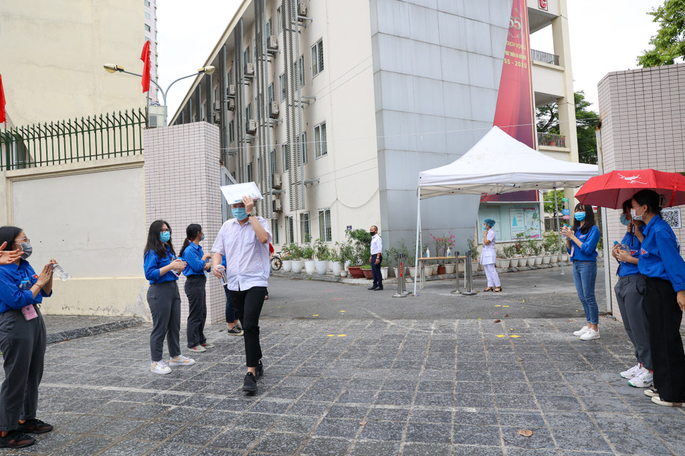 Các thí sinh đầu tiên bước ra khỏi phòng thi trong sự cổ vũ nồng nhiệt của các sinh viên tình nguyện. (Ảnh: Minh Sơn/Vietnam+)