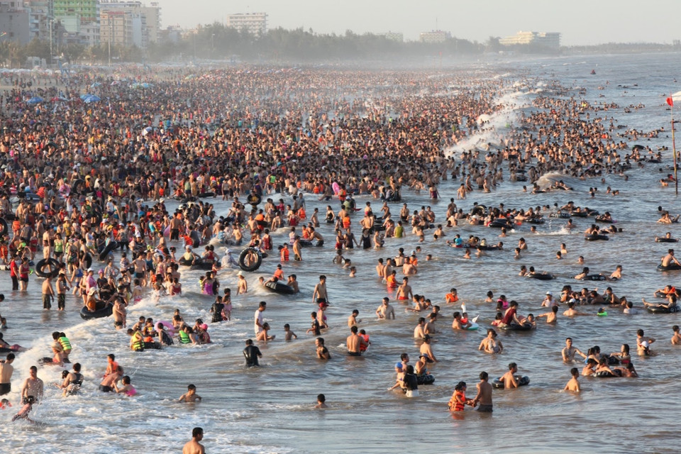 Mỗi ngày, biển Sầm Sơn (Thanh Hóa) đón hàng chục nghìn người đến để tắm biển, tránh nắng. (Ảnh: PV/Vietnam+)
