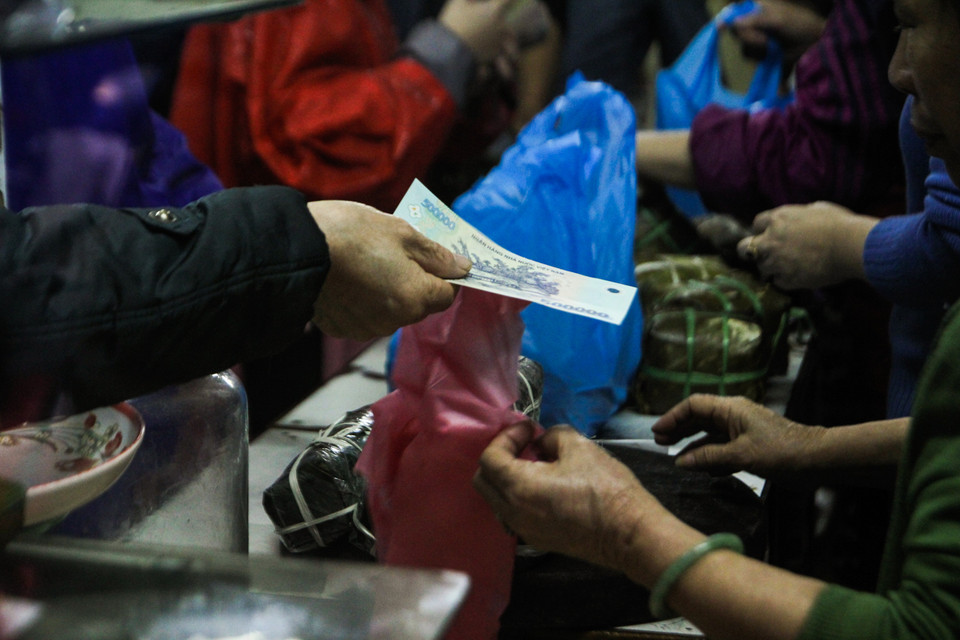 Giáp Tết, nhiều người vẫn kiên nhẫn chờ đợi đến lượt mình mua hàng, tuyệt nhiên không có cảnh chen lấn xô đẩy. Nhìn khung cảnh nhiều người nhớ về thời bao cấp. (Ảnh: Minh Sơn/Vietnam+)