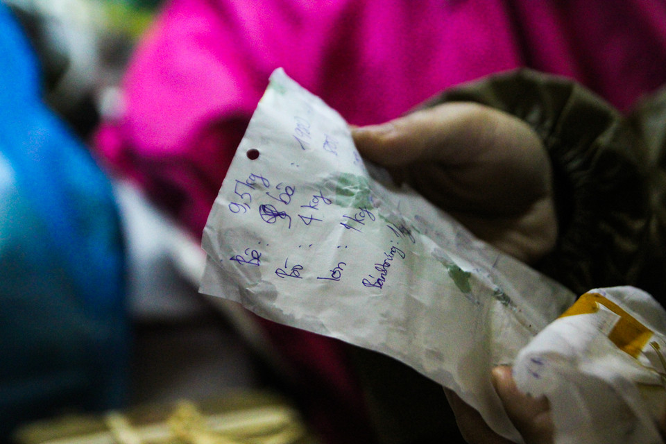 Để mua được hàng, nhiều người đã phải xếp hàng từ 6 giờ sáng, muốn mua được hàng phải đợi 30-45 phút. Có người mua nhiều phải ghi ra giấy để cửa hàng chuẩn bị. (Ảnh: Minh Sơn/Vietnam+) 