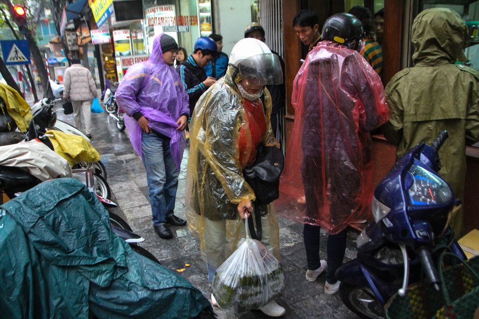 Từ nhiều năm nay, cứ cận Tết Nguyên đán, nhiều người dân Hà Nội lại tấp nập xếp hàng chờ đợi mua bánh chưng, giò chả tại cửa hàng Quốc Hương, số 9 Hàng Bông. (Ảnh: Minh Sơn/Vietnam+)
