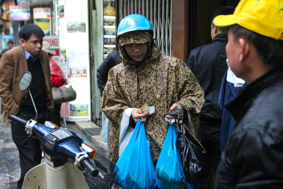 Bánh chưng cửa hàng đã hết sạch từ sáng nhưng nhiều người vẫn kiên nhẫn chờ đợi hơn tiếng đồng hồ để lấy được mẻ bánh mới nhất. (Ảnh: Minh Sơn/Vietnam+)