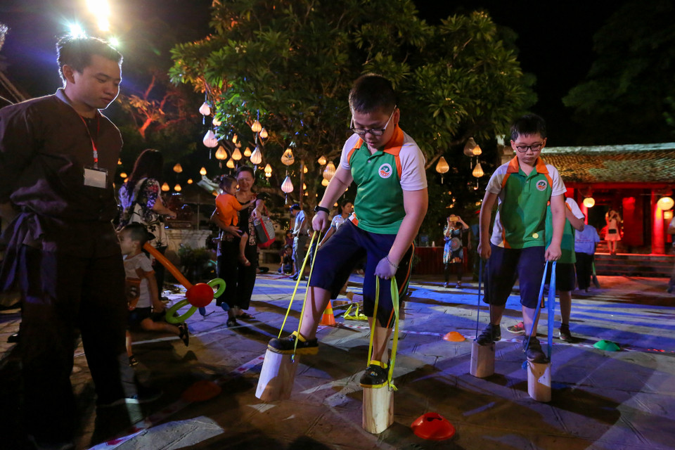 Từ đó ông bà, cha mẹ, anh chị có thể giúp khơi gợi lòng tự hào và phát huy tinh thần gìn giữ bản sắc văn hóa truyền thống dân tộc cho các em nhỏ một cách tự nhiên. (Ảnh: Minh Sơn/Vietnam+)