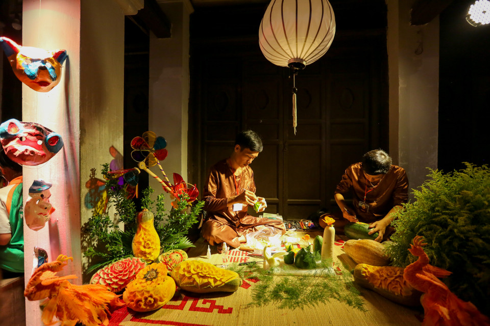 Hàng trăm nghệ nhân khắp Việt Nam cùng tham gia trình diễn nghệ thuật cắt tỉa và sắp đặt rau củ quả, mâm cỗ trung thu Hà Nội xưa, làm bánh trung thu truyền thống hay đùm cốm lá sen cùng các em nhỏ. (Ảnh: Minh Sơn/Vietnam+)