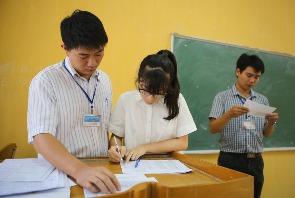 Cán bộ hướng dẫn sẽ ghi xác nhận những sai sót về họ, tên, đối tượng, hộ khẩu thường trú, khu vực của thí sinh và chuyển những thông tin này cho ban thư ký hội đồng thi xem xét, cập nhật vào phần mềm quản lý thi. (Ảnh: Minh Sơn/Vietnam+)