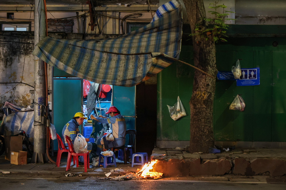Những công nhân vệ sinh môi trường chuẩn bị vào ca trực từ đêm đến sáng. (Ảnh: Minh Sơn/Vietnam+)