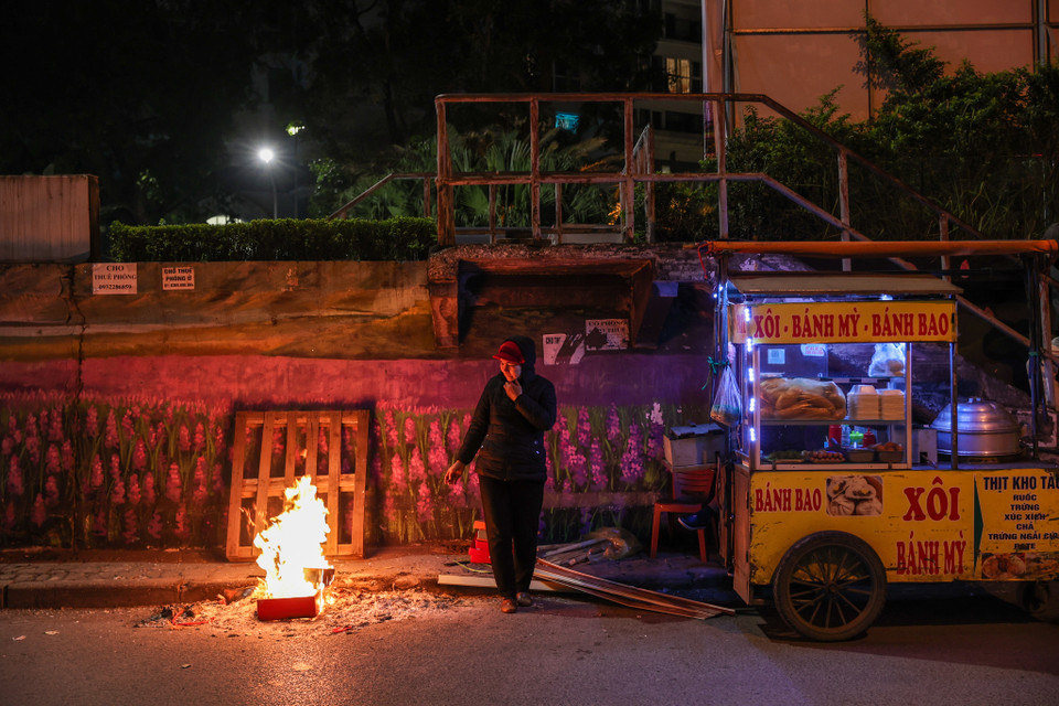 "Mùa Đông trời rét, biết là khách ít nhưng tôi vẫn gắng gượng, cố bán để mưu sinh. Nhiều hôm trời lạnh quá tôi phải mặc áo mưa, gom góp củi đốt để tránh rét," cô Dung tâm sự. (Ảnh: Minh Sơn/Vietnam+)