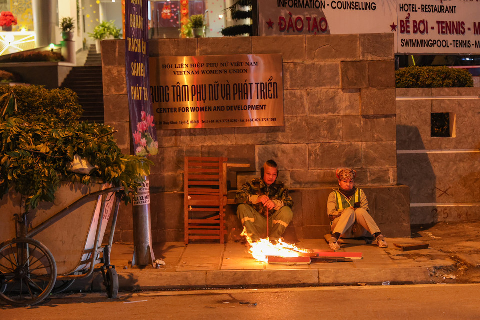 "Những đêm như đêm nay cực lắm vì lúc làm việc là lúc nhiệt độ xuống thấp nhất trong ngày. Tôi chỉ mong có một cái Tết no đủ," một người công nhận vệ sinh môi trường tại Hà Nội chia sẻ. (Ảnh: Minh Sơn/Vietnam+)
