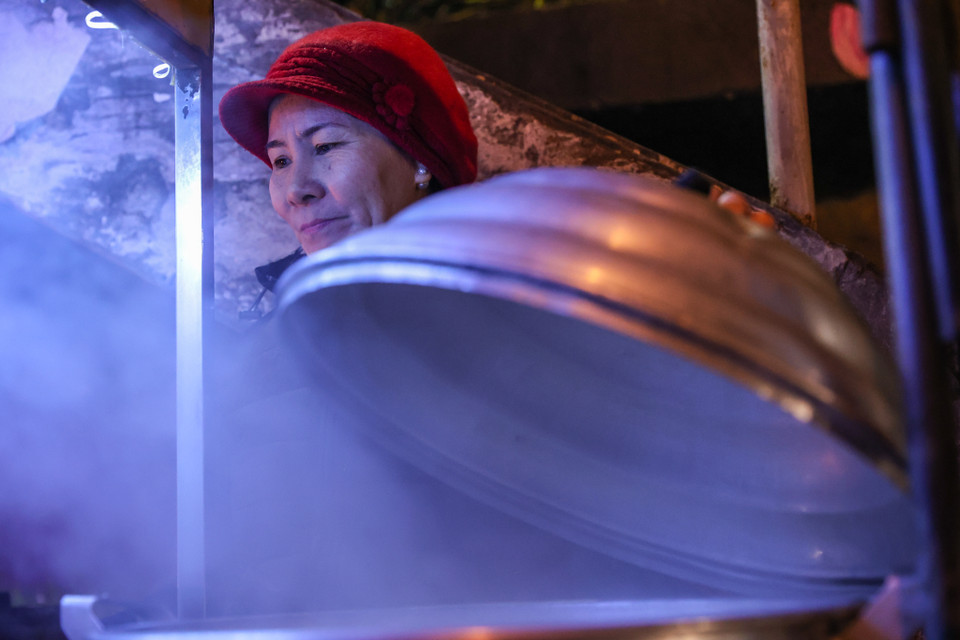 Cô Phạm Thị Dung, một người bán hàng rong trên đường Hồng Hà, bắt đầu công việc từ chập tối đến 4 giờ sáng mới về nhà. (Ảnh: Minh Sơn/Vietnam+)