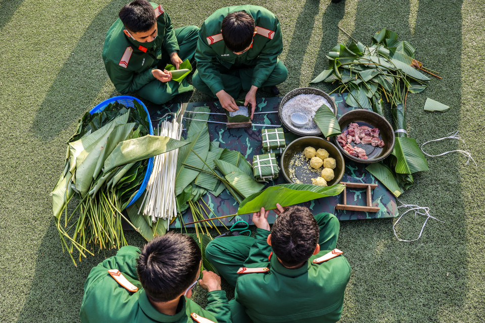 Những chiếc bánh chưng vuông vắn, xanh ngắt dần thành hình qua những bàn tay khéo léo của các cán bộ, chiến sỹ. (Ảnh: Minh Sơn/Vietnam+)