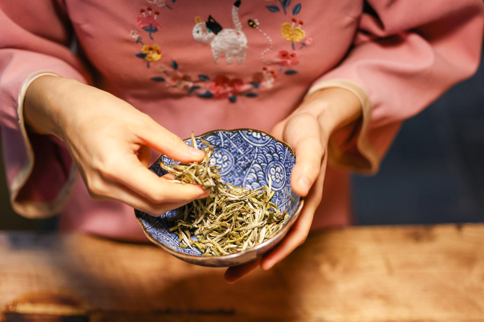 Để pha được ấm trà ngon, thơm, vừa nước cần có một trà nương tinh tế, nhanh nhạy và am hiểu về trà. Một trà nương như Linh phải kiểm tra tỉ mỉ, vừa dùng thị giác cả khứu giác để nhận biết những lá trà có đủ tiêu chuẩn để pha không. (Ảnh: Minh Sơn/Vietnam+)