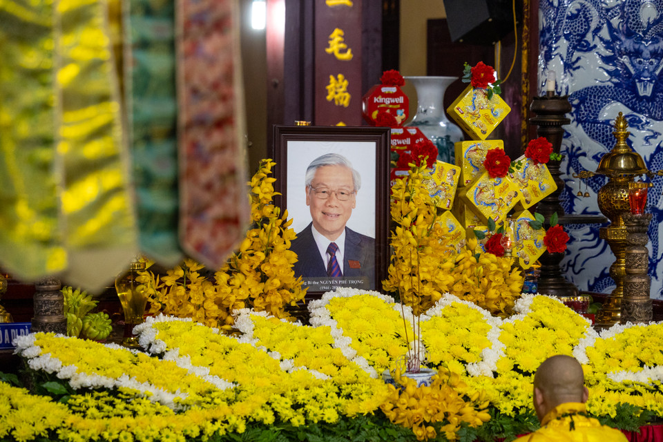 Di ảnh của Tổng Bí thư được đặt trang trọng trong chùa Quán Sứ, xung quanh được trang trí hoa lan và cúc vàng. (Ảnh: Minh Sơn/Vietnam+)