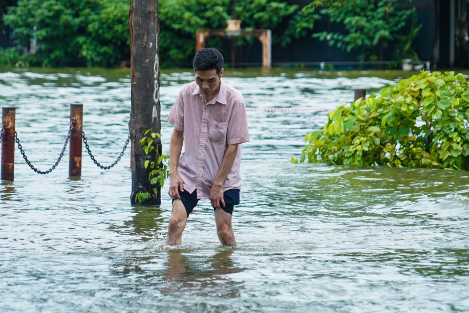 Nước ngập cao đến đầu gối khiến việc đi lại của người dân gặp nhiều khó khăn. (Ảnh: Việt Anh/Vietnam+)