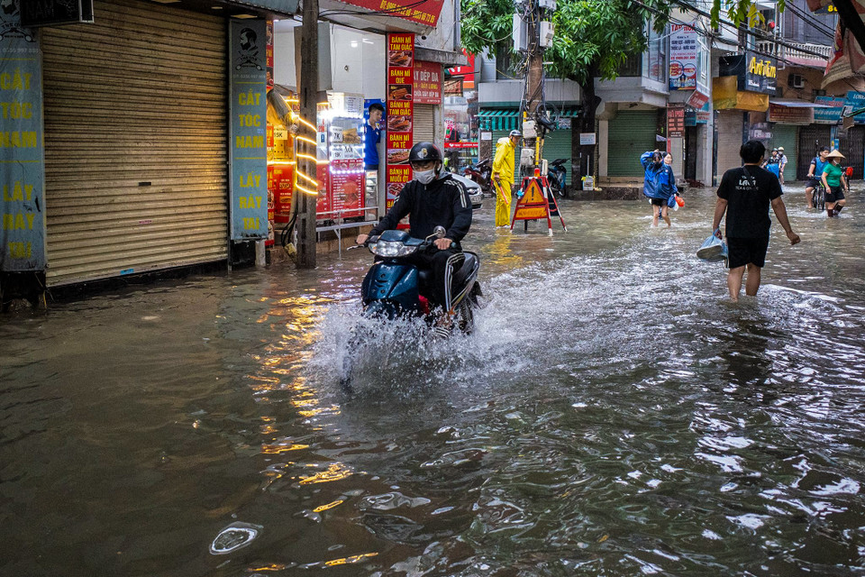 Mặc dù mưa lớn đã tạnh từ lâu nhưng nhiều tuyến phố Thủ đô vẫn chìm trong biển nước. (Ảnh: Minh Hiếu/Vietnam+)