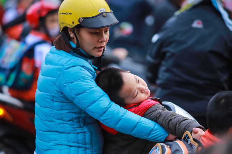 Việc phải đi học sớm trong thời tiết giá lạnh khiến nhiều em học sinh lộ rõ vẻ uể oải. (Ảnh: Minh Sơn/Vietnam+)