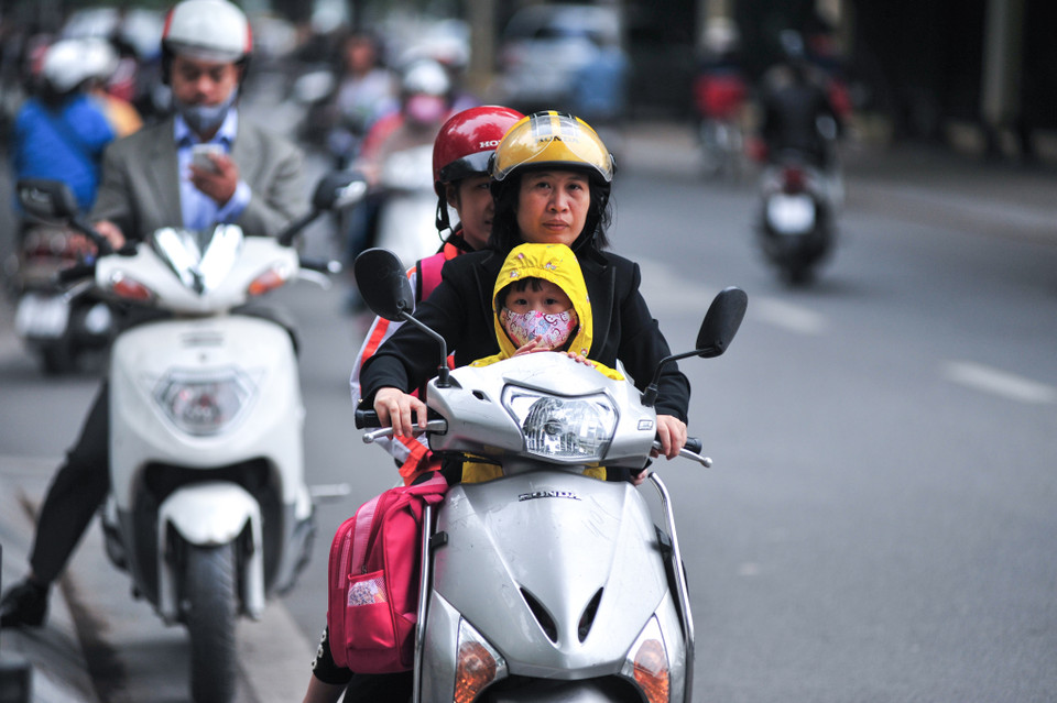 Những ngày này Hà Nội nhiệt độ xuống thấp khiến cho các em học sinh phải dậy sớm đến trường trong giá rét, nhiều em được bố mẹ kèm tới tận trường. (Ảnh: Minh Sơn/Vietnam+)