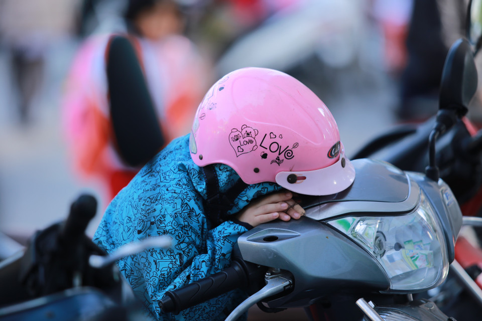 Một học sinh ngủ gật khi chờ phụ huynh mua đồ ăn sáng. (Ảnh: Minh Sơn/Vietnam+)